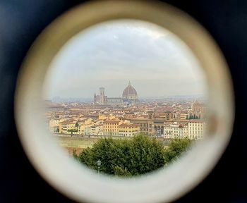 Panoramic view of cityscape against sky seen through window