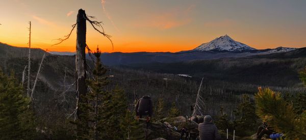 People on mountain against sky during sunset