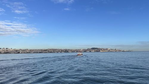 Sailboats in sea against blue sky