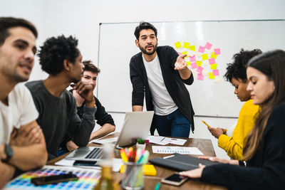 Businessman giving presentation to colleagues in creative office