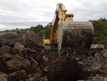 Construction site by rocks against sky