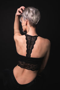 Rear view of woman against black background