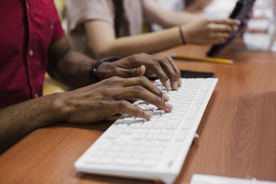 Midsection of woman using laptop on table