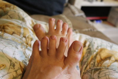 Close-up of woman's feet on bed