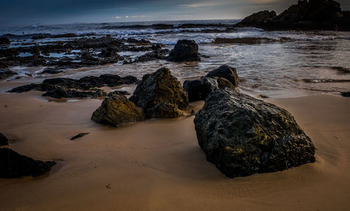 Rocks on beach against sky