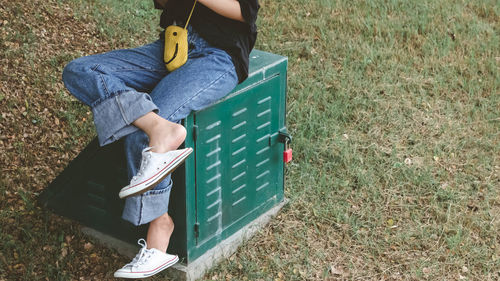 Low section of person holding book on field