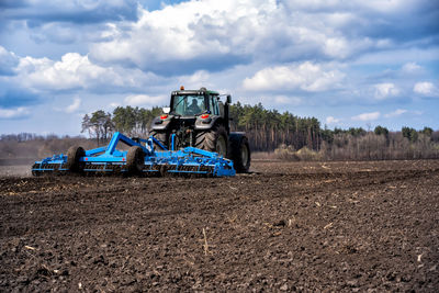 Tractor on agricultural field against sky