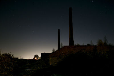 Silhouette smoke stacks against star field