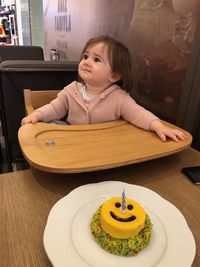 Cute girl sitting on table at cafe