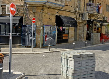 Road sign on street by buildings in city