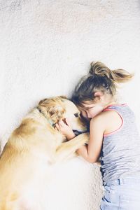 Rear view of woman with dog against wall