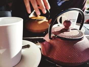 Close-up of teapot and mug on table at cafe