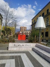Information sign by building against sky