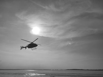 Low angle view of airplane flying over sea against sky