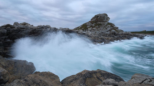 Panoramic shot of rocks in sea against sky