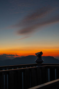 Silhouette mountain against orange sky during sunset