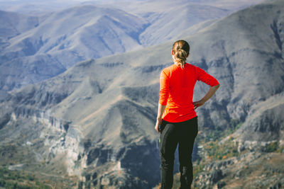 Rear view of woman standing against mountains