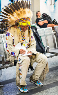 Full length of man sitting outdoors