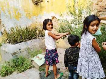 Siblings standing against wall