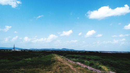 Road amidst field against sky