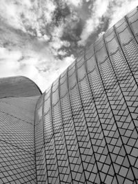 Low angle view of modern building against cloudy sky
