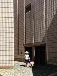 Woman walking along built structures