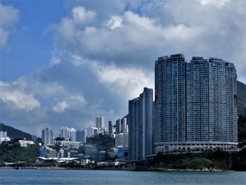 Modern buildings by sea against sky