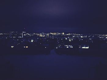 Illuminated cityscape against sky at night
