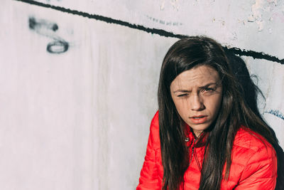 Close-up of portrait of woman against wall