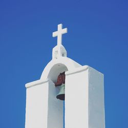 Greek church bell tower against blue sky 