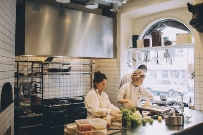 Multi-ethnic chefs preparing food on kitchen counter at restaurant