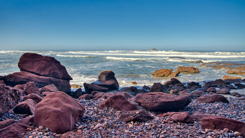 Rocks on beach against sky