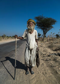 Portrait of man standing on street against clear sky