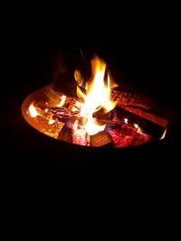 Close-up of lit candles against black background