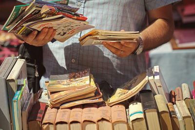 Close-up of a man holding books at flea market