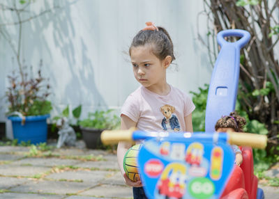 Cute young girl playing in the backyard on a sunny day