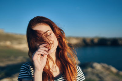 Portrait of beautiful woman against sky