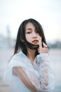 Portrait of woman in raincoat standing outdoors