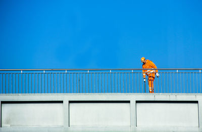 Man standing against blue sky