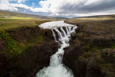 Scenic view of waterfall against sky