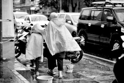 Mother and daughter, rainfalling , walking, rain coat