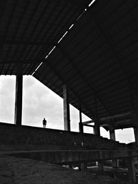 Low angle view of people on bridge against sky