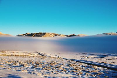 Scenic view of snowcapped mountain against blue sky