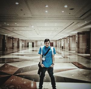 Full length portrait of man standing on illuminated ceiling