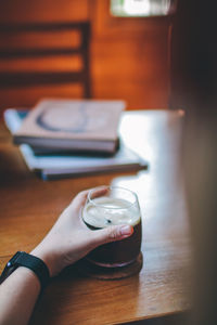 Midsection of woman holding coffee cup on table