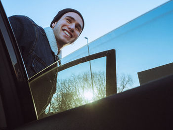 Smiling man seen through car window