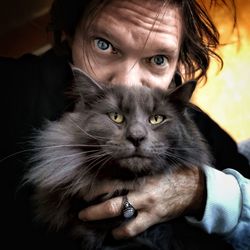 Portrait of man with cat