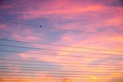 Low angle view of cables against sky during sunset