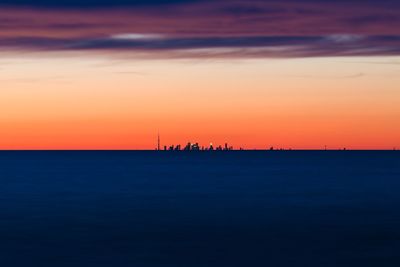 Silhouette of boat in sea during sunset