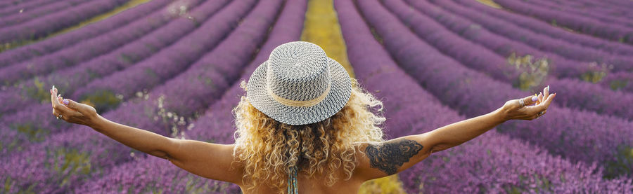 Low angle view of woman with pink flower on field